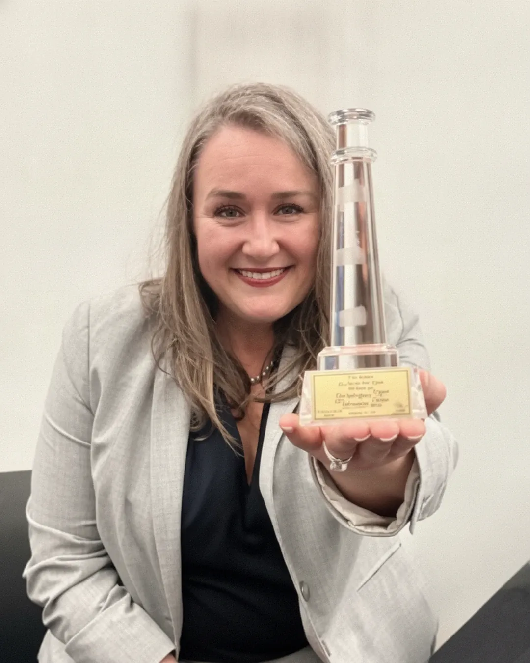 Allison Corry holding the 2025 Dean S. Ammer Award trophy